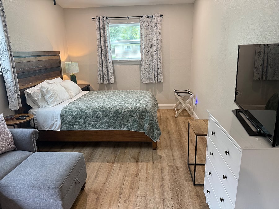Queen size bed, Small couch, Dresser and television.