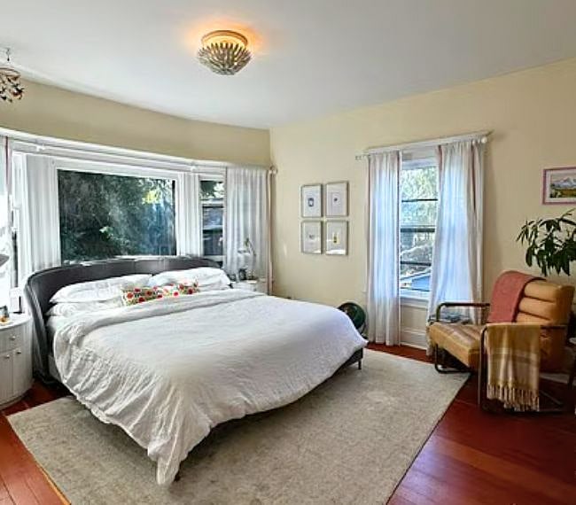 Primary bedroom including 2 closets (1 walk-in), frame TV and expansive windows