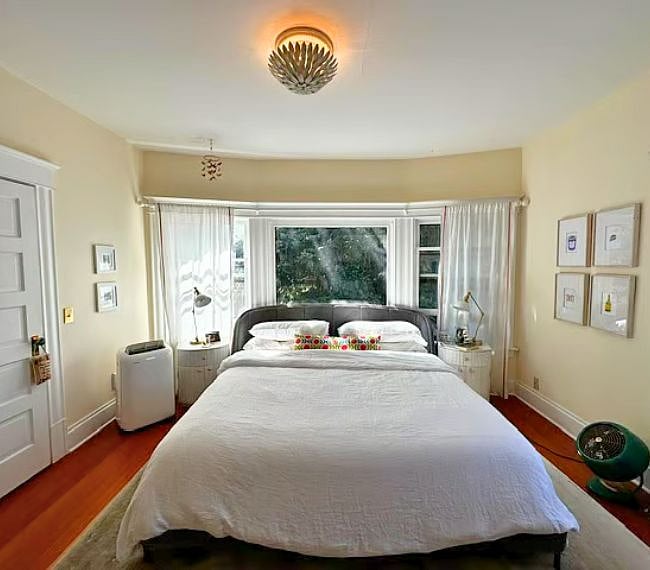 Primary bedroom including 2 closets (1 walk-in), frame TV and expansive windows
