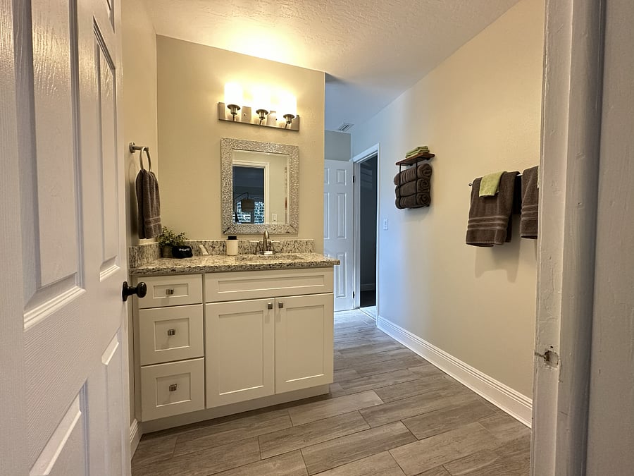 The downstairs bathroom is accessible from both the den and the downstairs bedroom. It includes a walk-in shower, toilet and vanity.