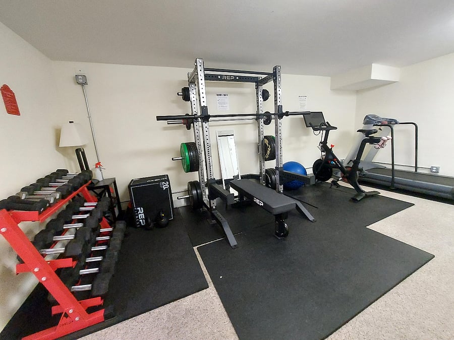 Resident fitness room with Peloton bike, treadmill, power rack, bench, REP dumbbells and plyo box
