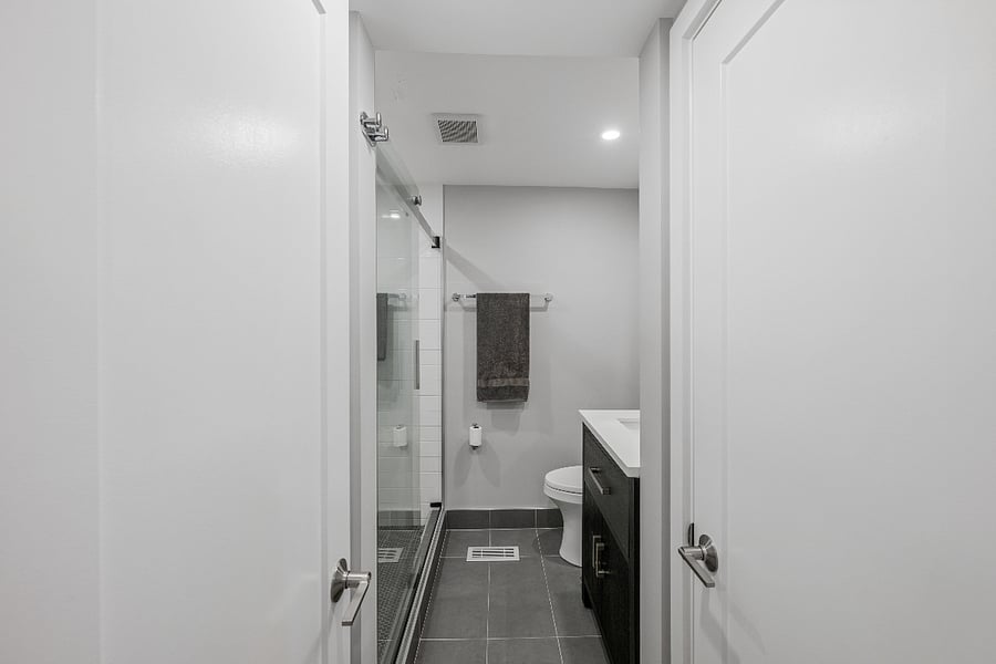 Comfortable bathroom with large walk-in shower with rain head and handheld showers.