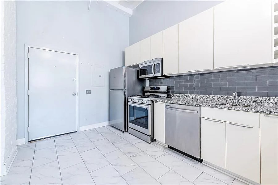 Updated full kitchen with granite countertops, stainless-steel appliances, gas range, dishwasher, microwave, and generous cabinetry