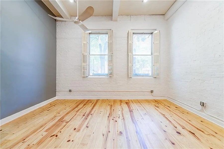 Large windows, exposed brick, and high ceilings bring natural light and character to the loft