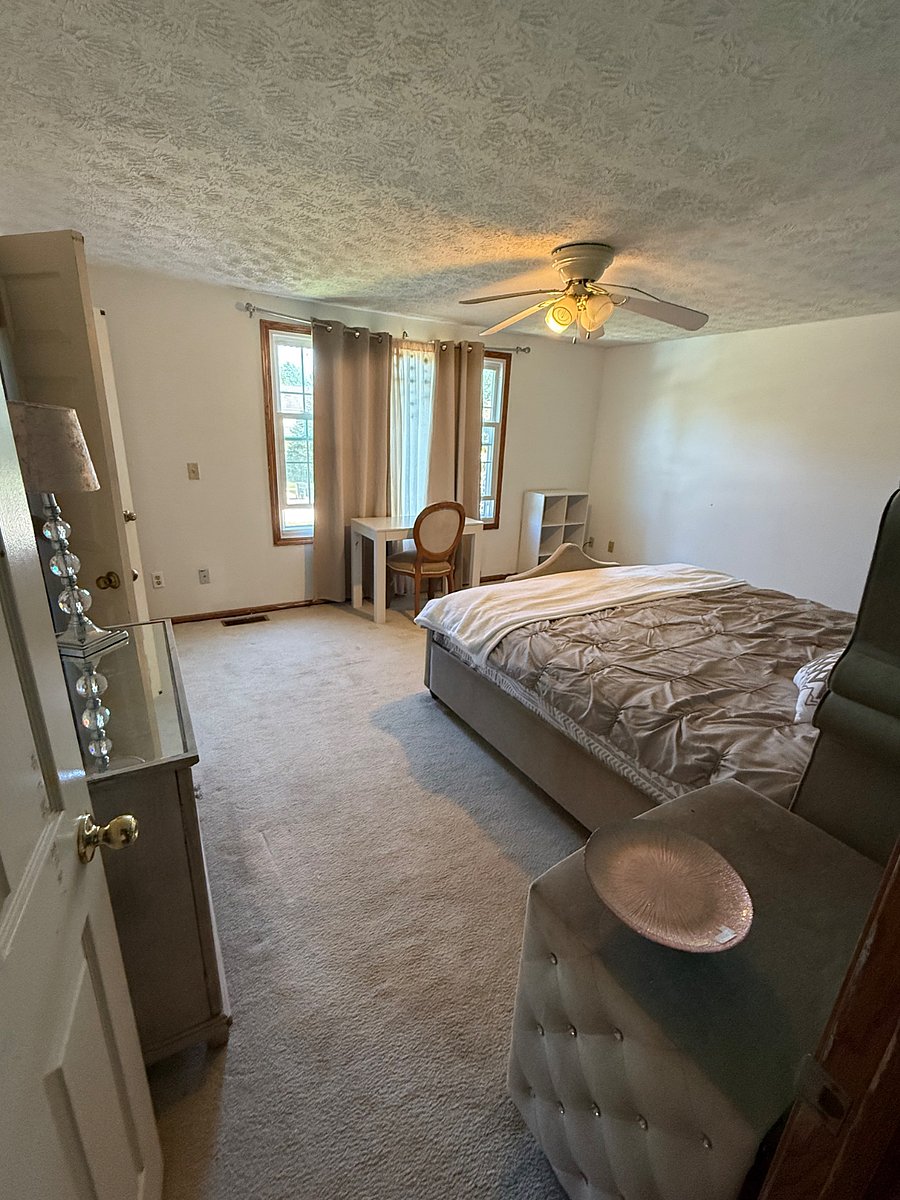     Bright Additional Bedroom  Spacious furnished bedroom featuring natural light, a ceiling fan, storage, and a dedicated desk area.