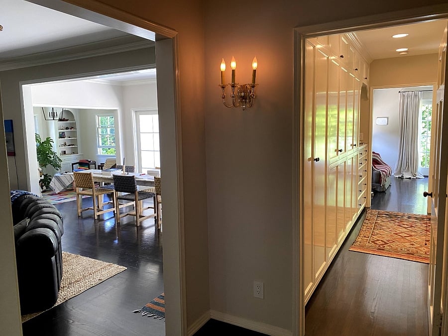 View from the entrance of the home, with the living space on the left and the storage-filled hallway leading to the bedroom on the right.