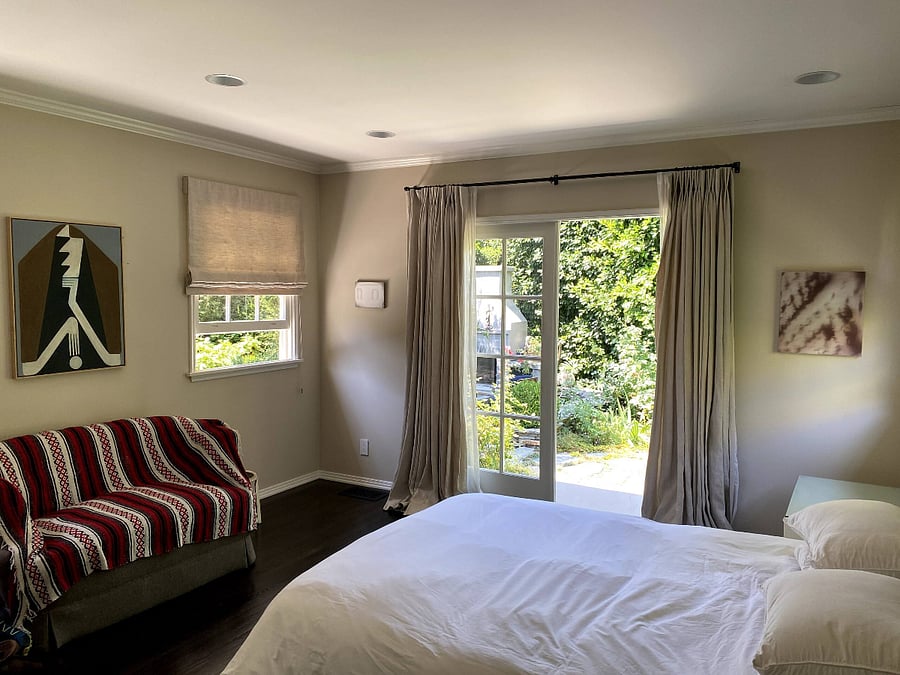 The master bedroom featuring seating and a queen-size bed with private access to the backyard and the chance to enjoy the beauty of nature.