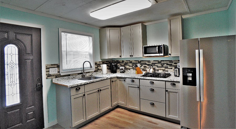 Kitchenette has plenty of cabinet and drawer space with gas cooktop, microwave, and full size refrigeratior.