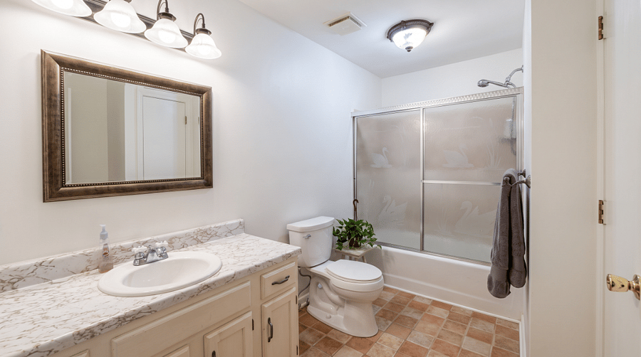 Bathroom #2 with vanity, tub, shower and built-in linen cupboard.
