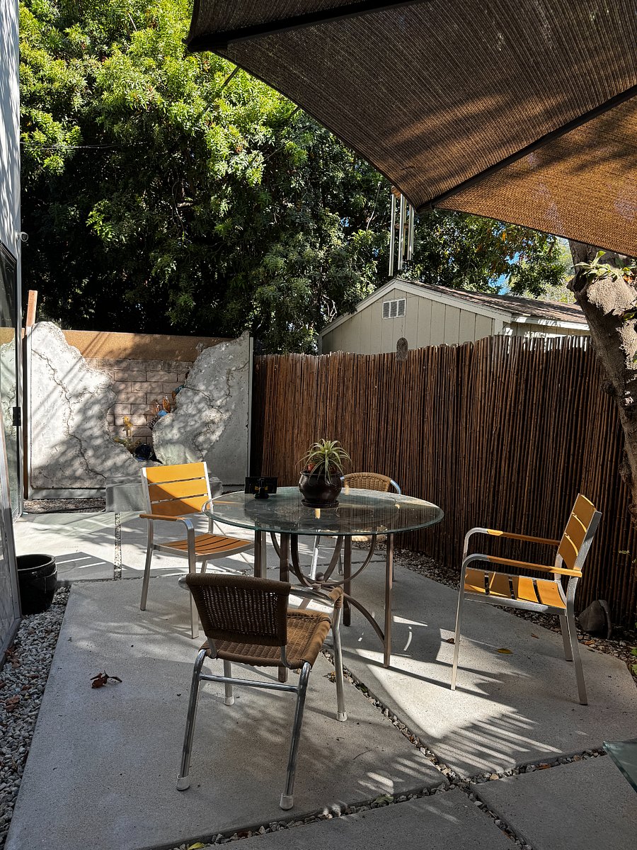 This is a private outdoor space with an illuminated granite slab, a large-scale glass and concrete sculpture adjacent to a BBQ.