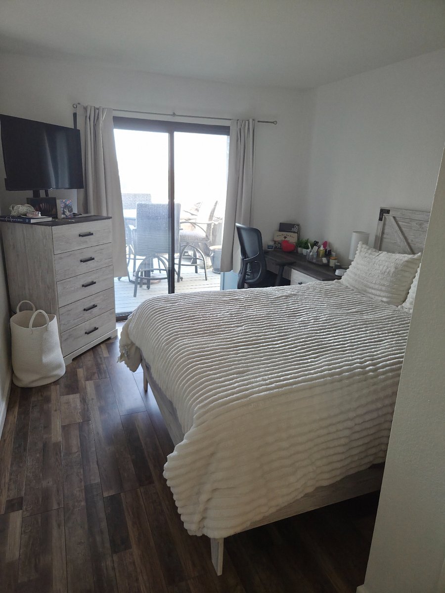 Main floor bedroom with queen size bed and add'l clothes drawers and nook off to the side. Access to the balcony. Has small ocean view.