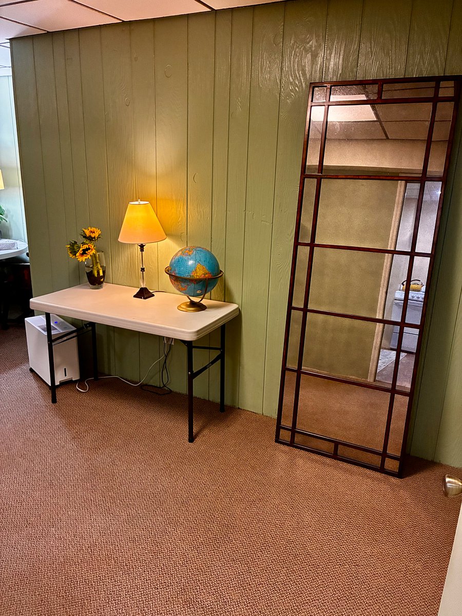 Side table in living area outside the Kitchen and bathroom with full length vintage mirror