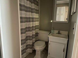 BATHROOM
Mid tone gray walls and tile, bright fixtures and accents. Nicely coordinated gray/white decorative accents.