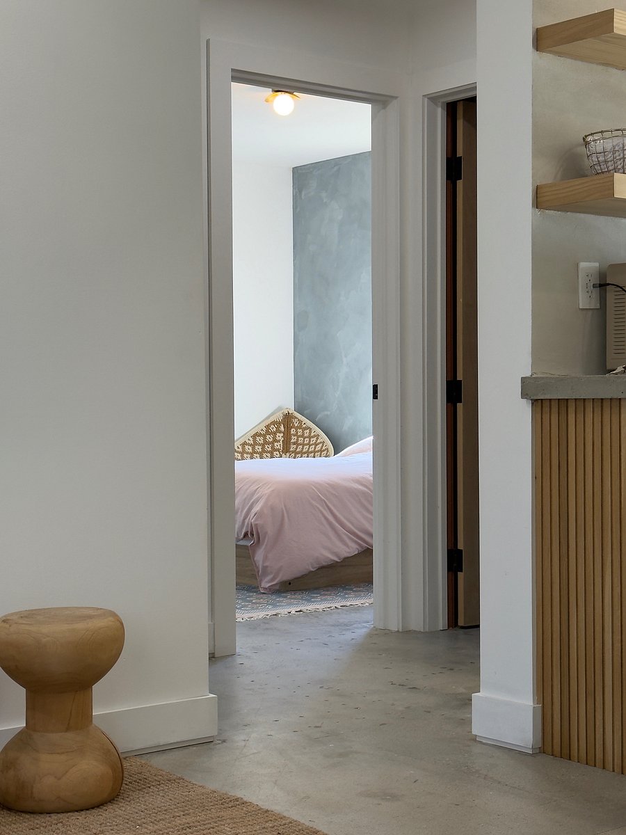 A peak into bedroom 1 that has an en suite, newly built bathroom with a walk-in curdles shower.
