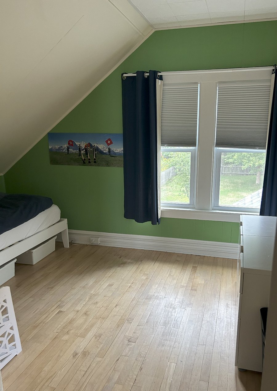 Twin XL bedroom with dresser and small closet, view out onto the enclosed backyard