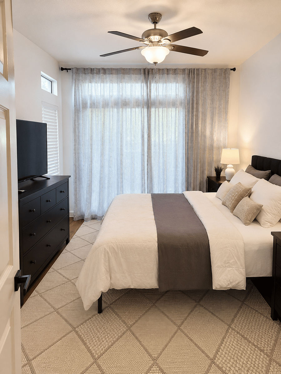 Bedroom with smart TV leading onto balcony 