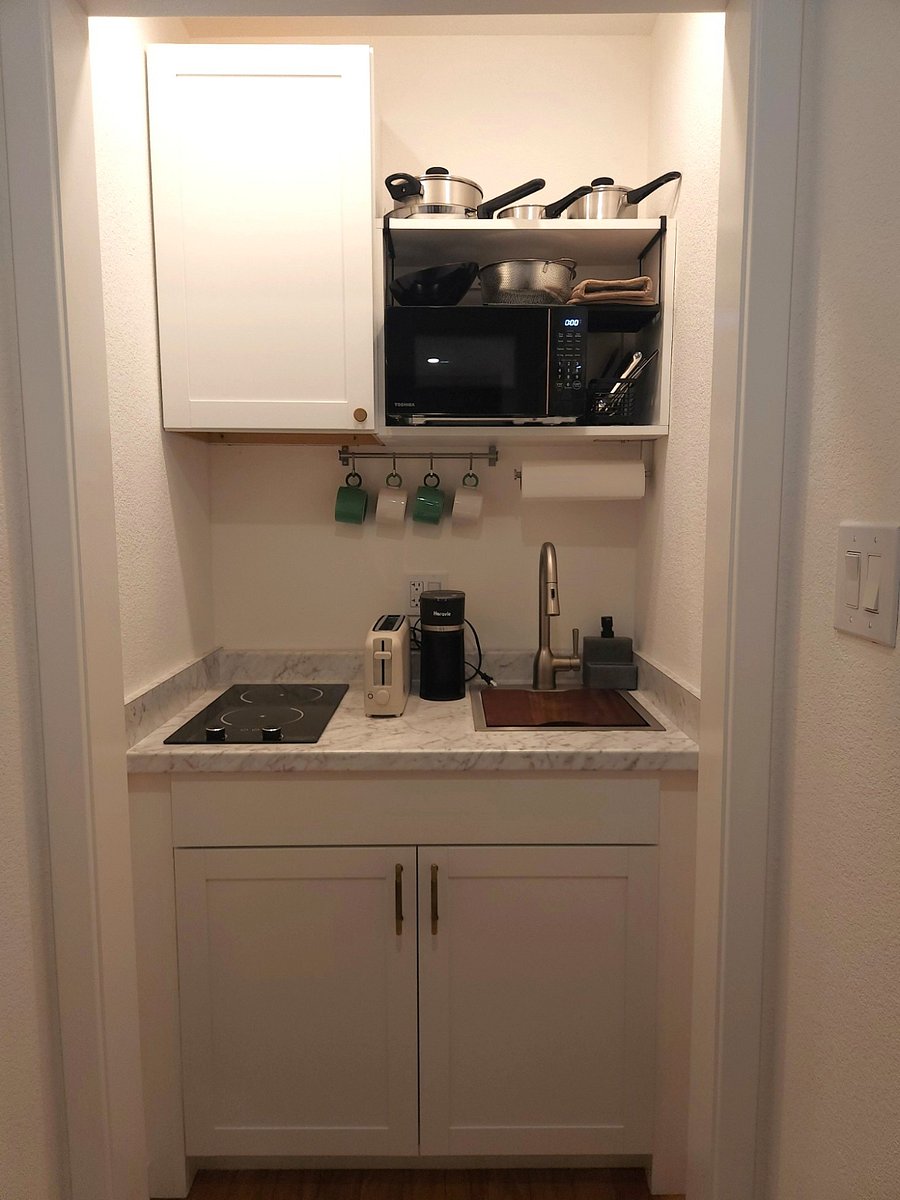 Kitchen has dual electric burners, sink with garbage disposal, toaster, coffee maker, electric kettle, plates, cups, glasses, wine glasses, whiskey glasses, pots, pans, etc.