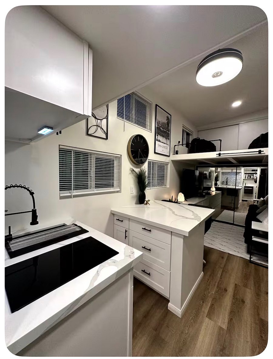 View of kitchenette, center table station, living area and upper loft (lounge loft).