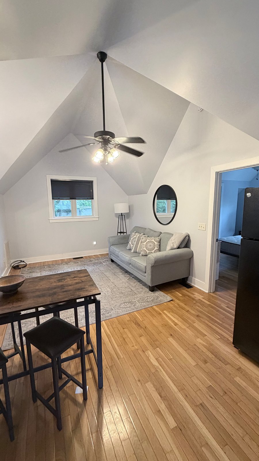 Living room with wood floors, ceiling fan in vaulted ceiling and lots of light!