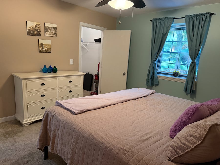 Bedroom 2. King size bed, walk-in closet, dresser, ceiling fan.