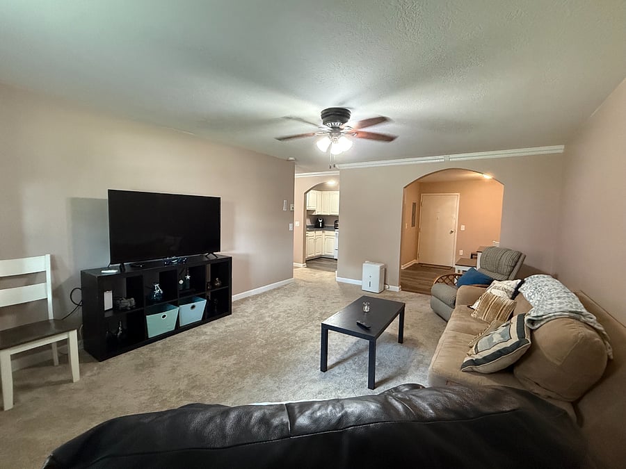 Living room, 55" TV, black leather power recliner, wall a/c and ceiling fan.