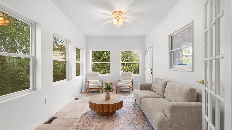 Bright sunroom with comfortable seating and plenty of natural light for relaxing or enjoying morning coffee.
