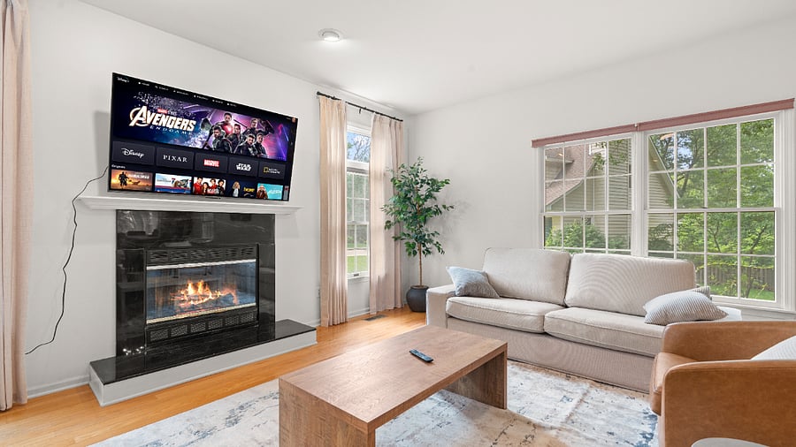 Inviting main living room with a cozy fireplace, comfortable furnishings, and large windows.