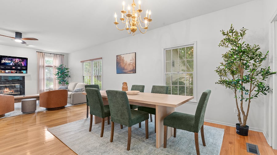 Spacious dining area with a large dining table and comfortable chairs, conveniently connected to the kitchen and sunroom.