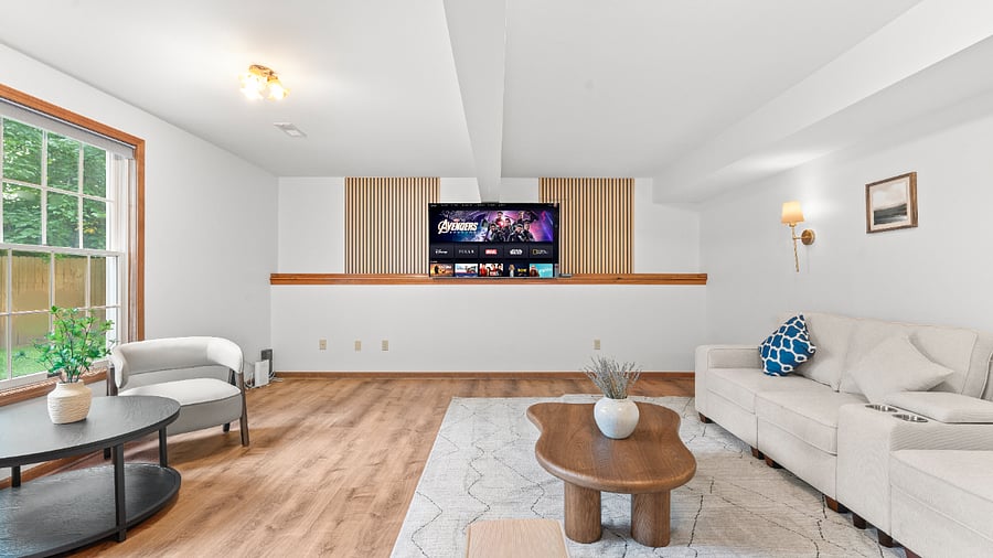 Spacious basement recreation lounge with generous seating and plenty of open space for relaxing, entertaining, or gathering with family and friends.
