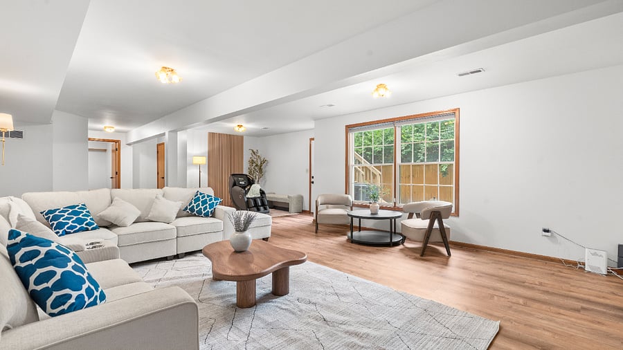 Spacious basement recreation lounge with generous seating and plenty of open space for relaxing, entertaining, or gathering with family and friends.
