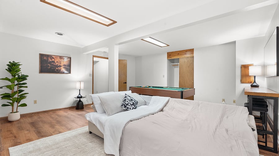 Flexible basement bedroom/lounge with a convertible sofa for comfortable seating or sleeping with pool table.