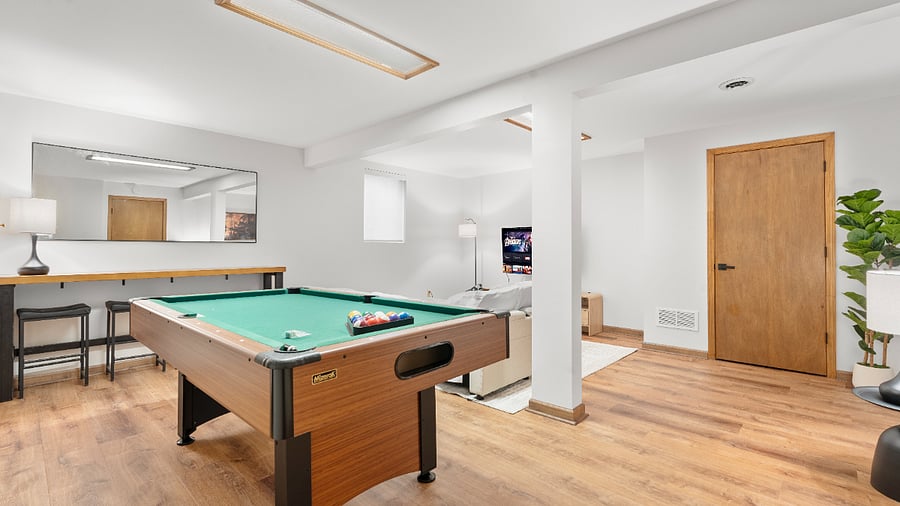 Flexible basement bedroom/lounge with a convertible sofa for comfortable seating or sleeping with pool table.