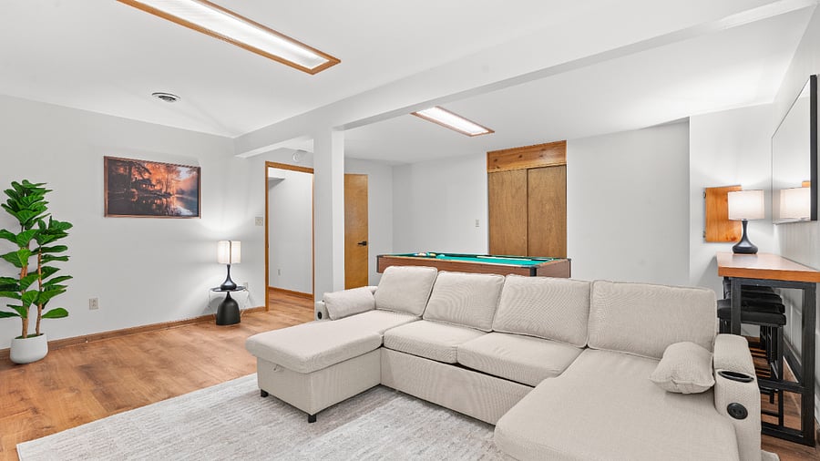 Flexible basement bedroom/lounge with a convertible sofa for comfortable seating or sleeping with pool table.