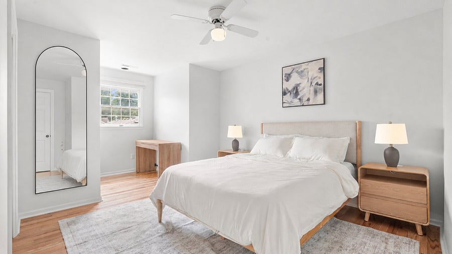 Inviting upper-level queen bedroom with clean linens, comfortable furnishings, and a dedicated writing desk.