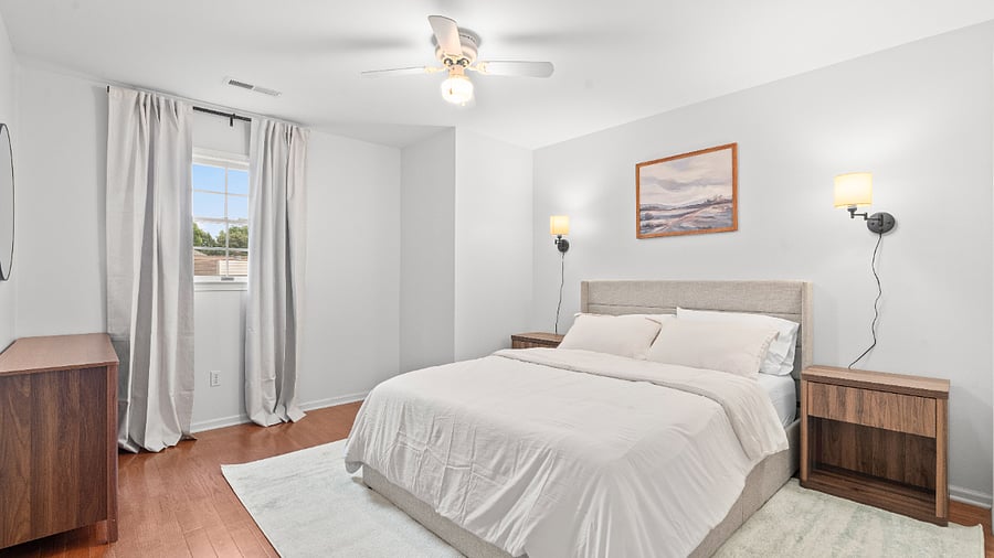 Comfortable upper-level bedroom with a queen bed, dresser, ceiling fan, and closet storage.