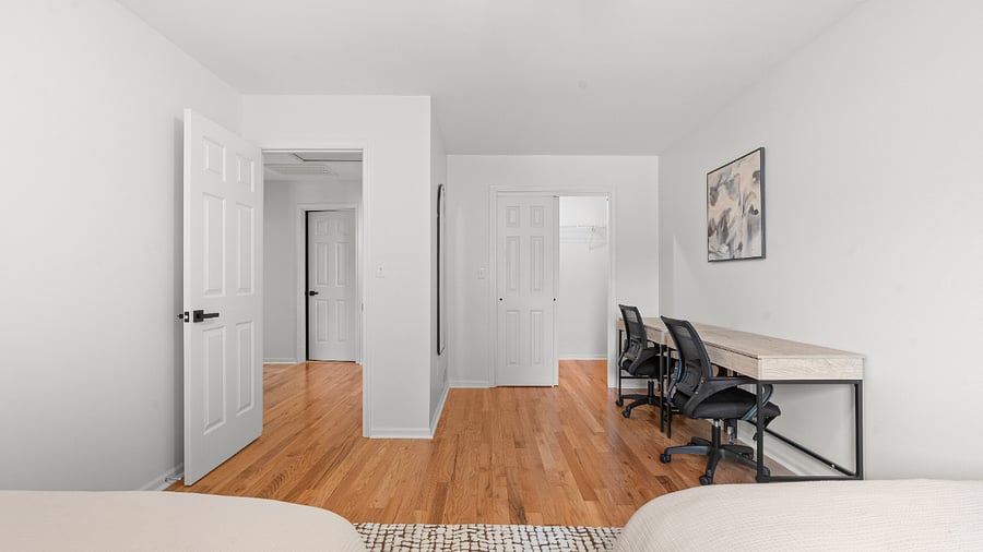 Upper-level bedroom with two full beds, two writing desks, and generous closet space.