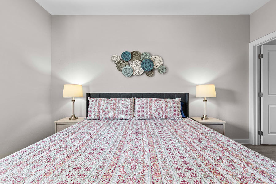 primary room with queen bed, dresser, and closet. Ensuite bathroom with shower tub combo.