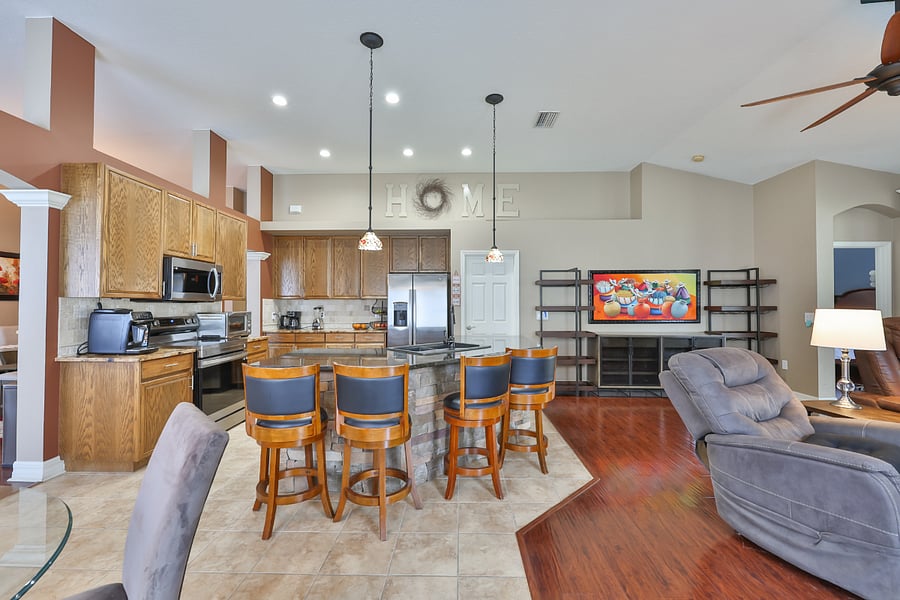 Seating at the kitchen island and walk-in pantry to the right of refrigerator