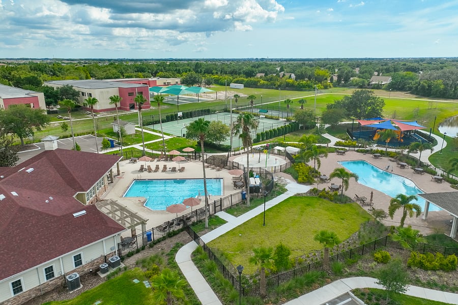 Aerial showing Clubhouse, Family pool, lap pool, Splash Pad, Playground, and Sport Courts all a short walk away