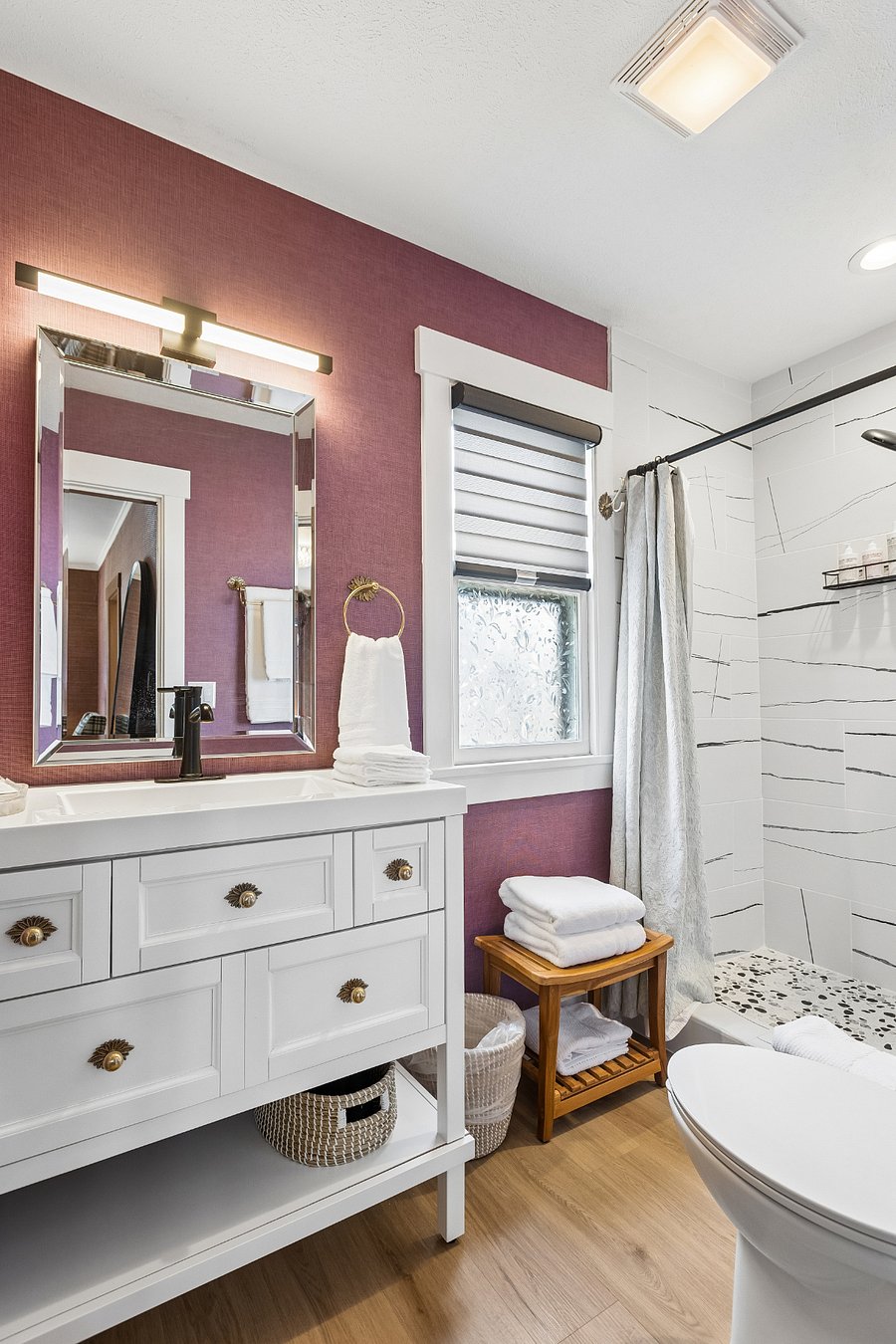 The modern bathroom includes a walk-in shower, complimentary starter kit of Malin+Goetz shampoo, conditioner, and body wash.