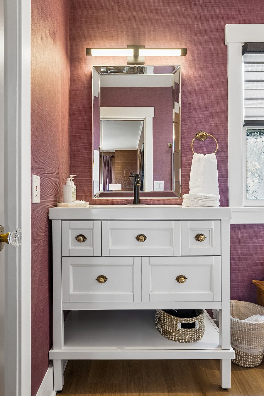 The rich textured wallpaper and spacious vanity create a warm, inviting space with plenty of storage for your stay.