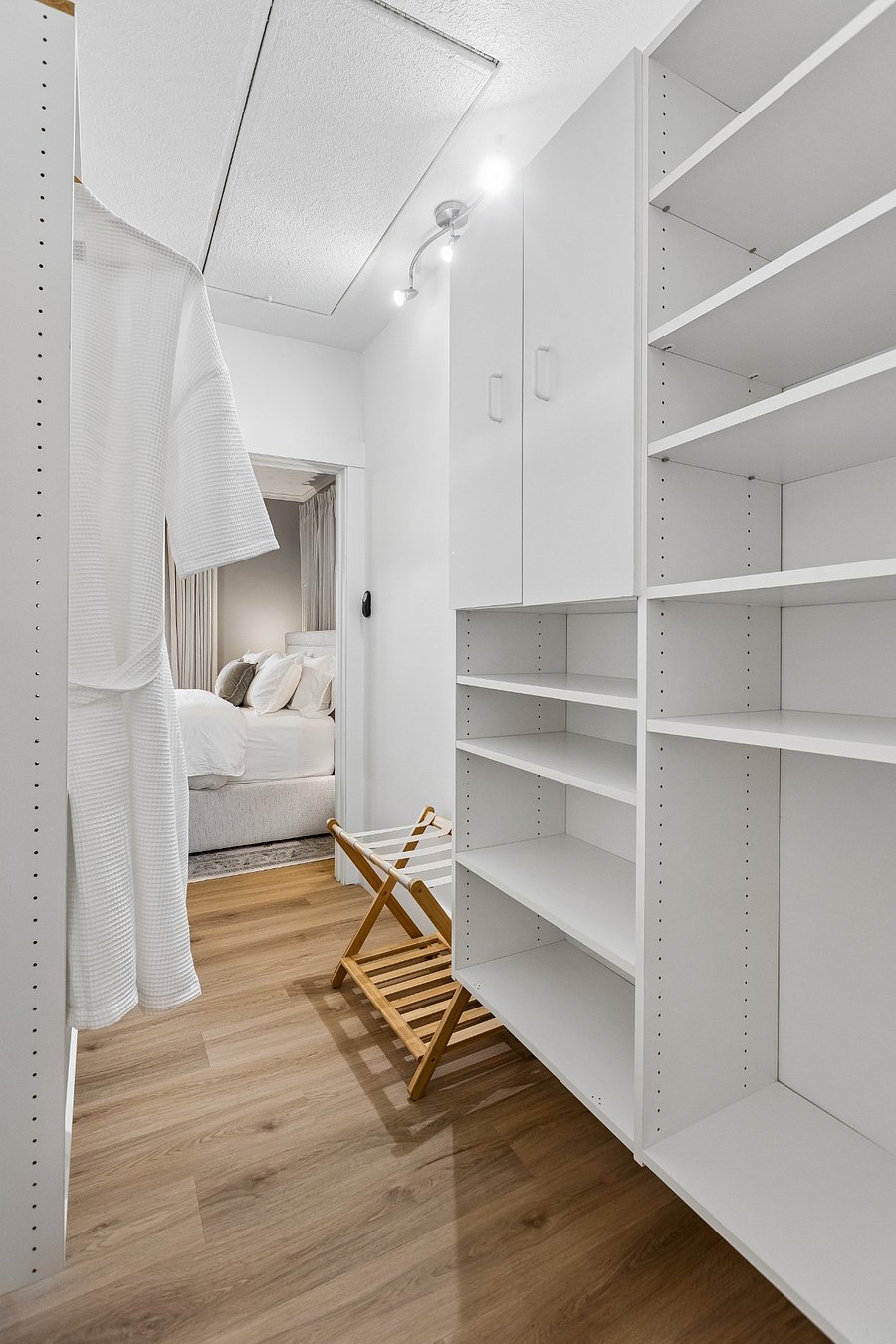 Unpack with ease in the spacious walk-in closet, complete with custom storage, luggage rack, and waffle robes.
