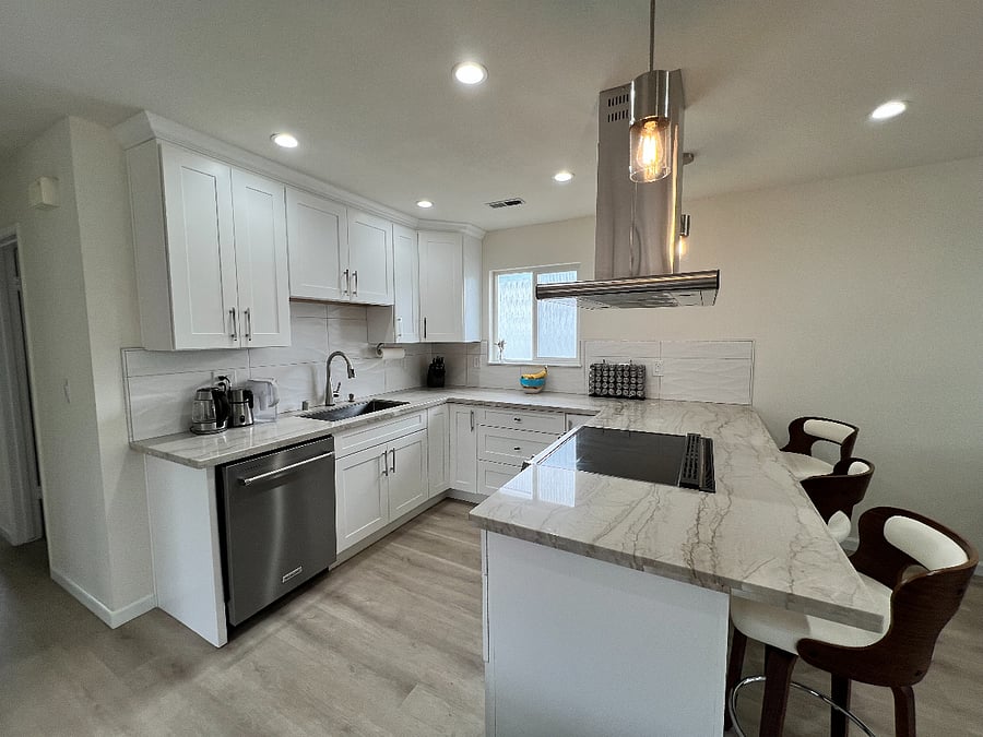 New kitchen with bar/bar stools, dishwasher, and induction stove/oven.