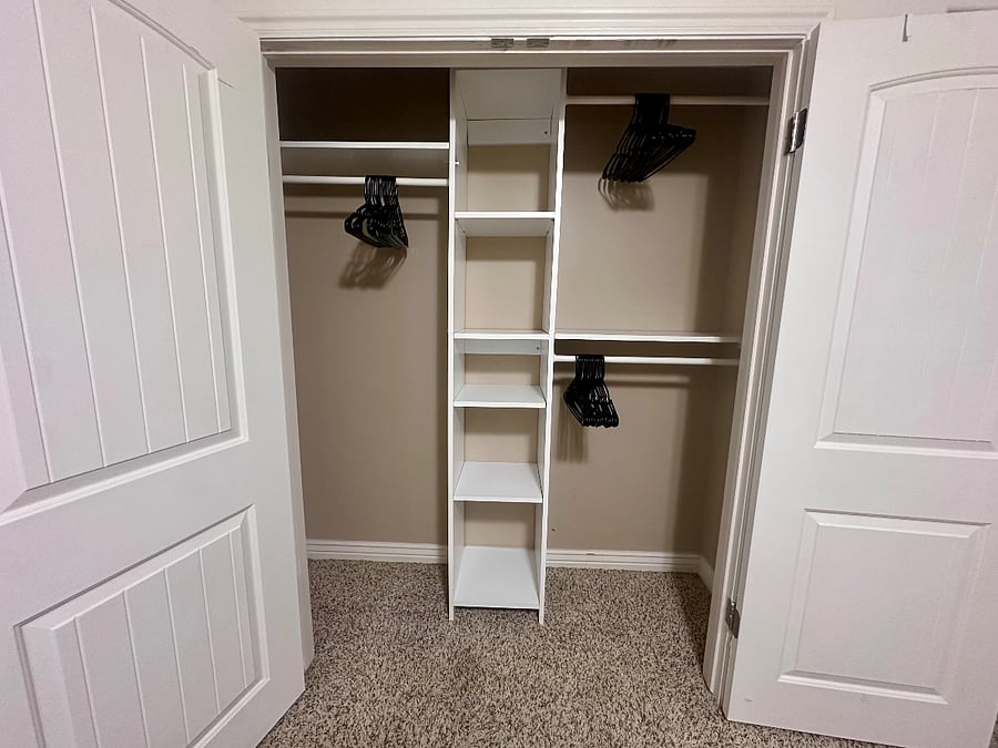 Private closet with built-in shelving, hanging space, and hangers provided.