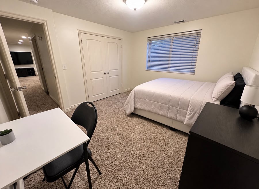 Private bedroom with closet, dresser and dedicated workspace