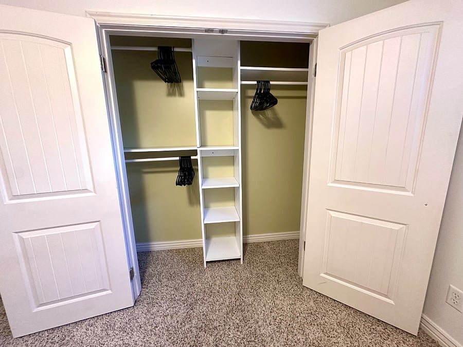 Spacious closet with built-in shelving and hangers provided