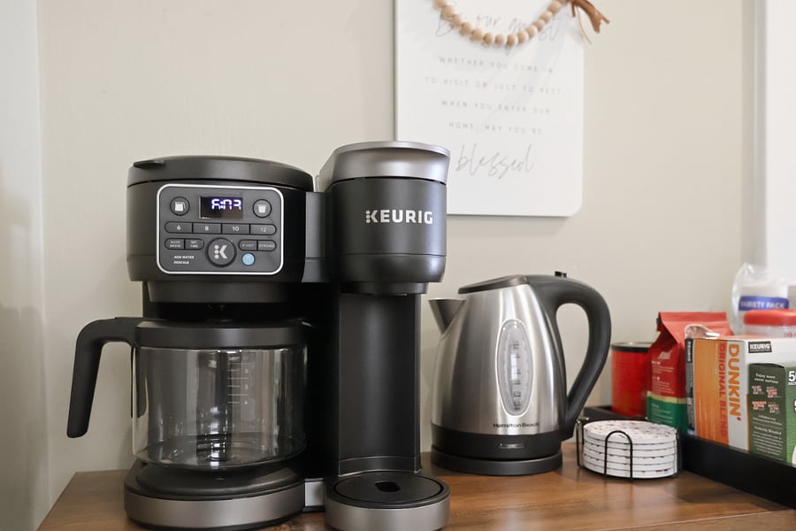 Enjoy our fully stocked coffee station, featuring a Keurig K-Duo, electric and stovetop kettles, French press, Moka pot, assorted mugs, to-go cups, coasters, and a selection of coffee and tea essentials.