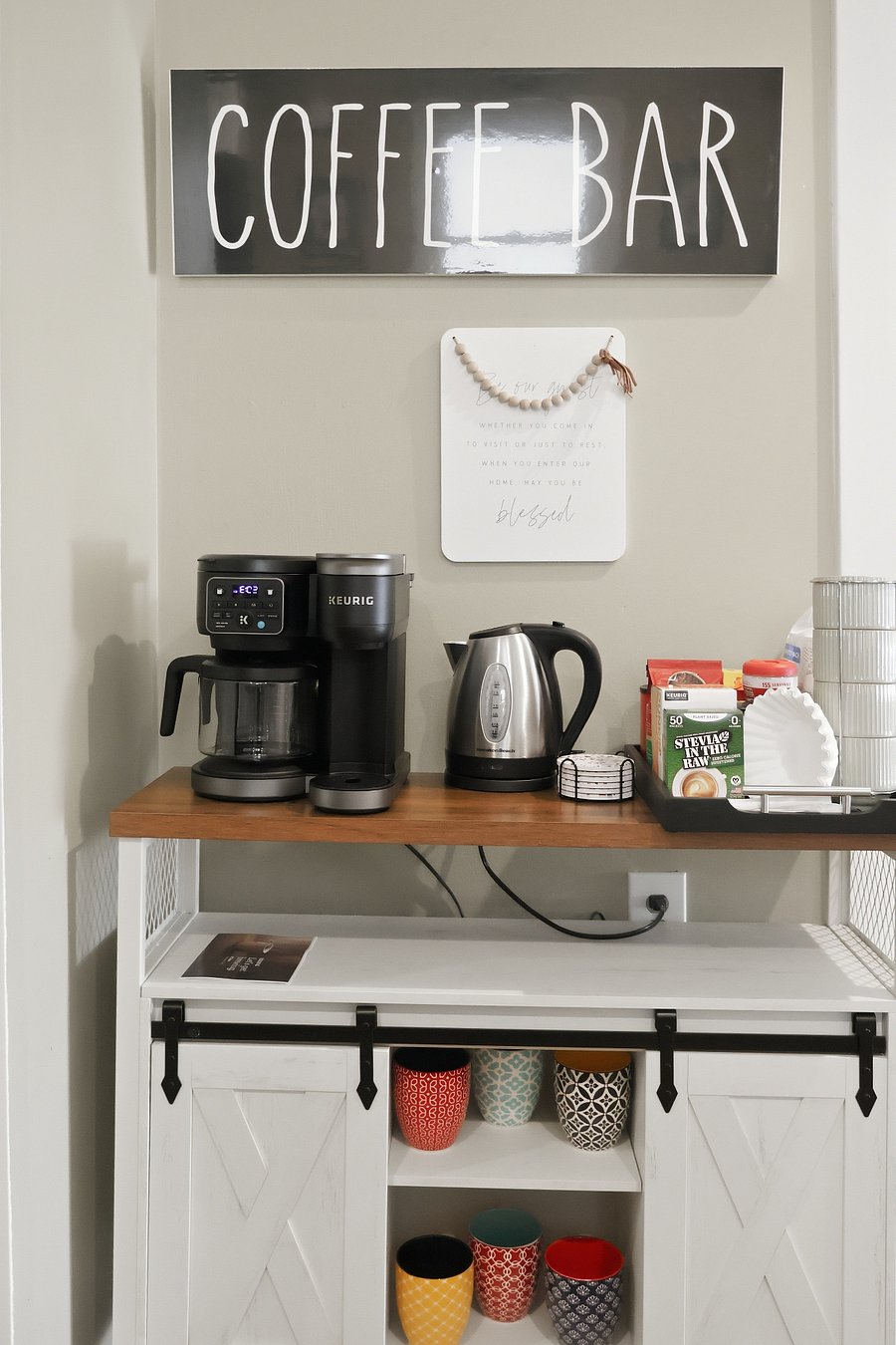 Enjoy our fully stocked coffee station, featuring a Keurig K-Duo, electric and stovetop kettles, French press, Moka pot, assorted mugs, to-go cups, coasters, and a selection of coffee and tea essentials.
