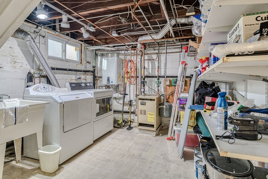 Washer and dryer in unfinished basement.