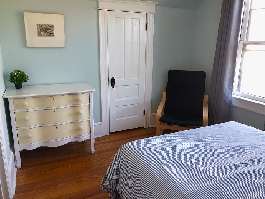 Back bedroom has full size bed, ceiling fan, 2 bedside tables, black out curtains, Ikea Poang easy chair and vintage dresser.